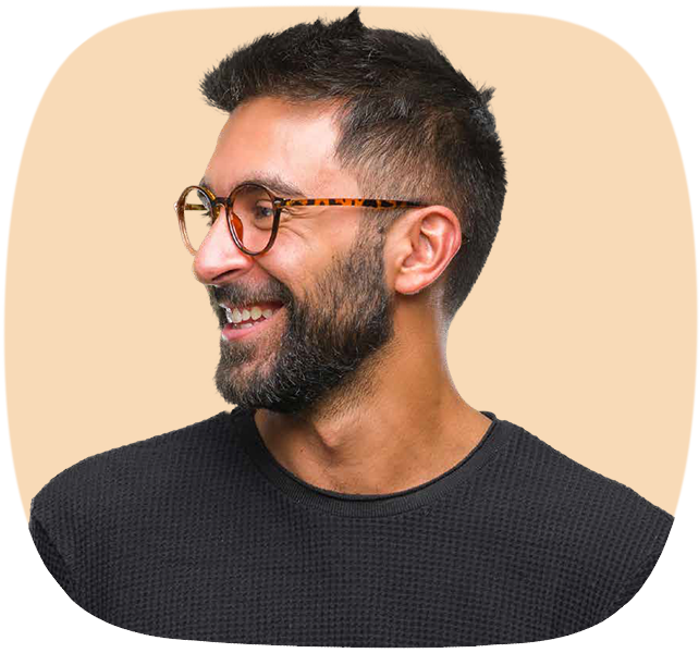 Das Seitenprofil eines lächelnden Mannes mit Brille, dunklen Haaren und Bart