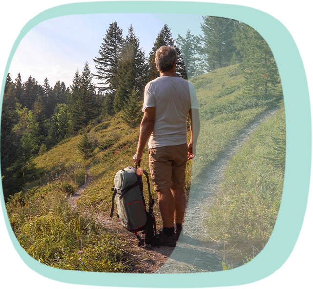 Ein Mann mit Gepäck auf einem Wanderweg Ein Mann mit Gepäck auf einem Wanderweg